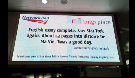 The Transvision digital screen in London's Kings Cross station displaying a haiku poem from a Twitter feed.